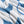 A close-up of a white and blue woven Indigenous blanket showing the soft texture and folds of the material.