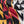 A close-up of a woven textile with a bold pattern in black, white, red, and mustard yellow, draped to show its texture and colors. 
